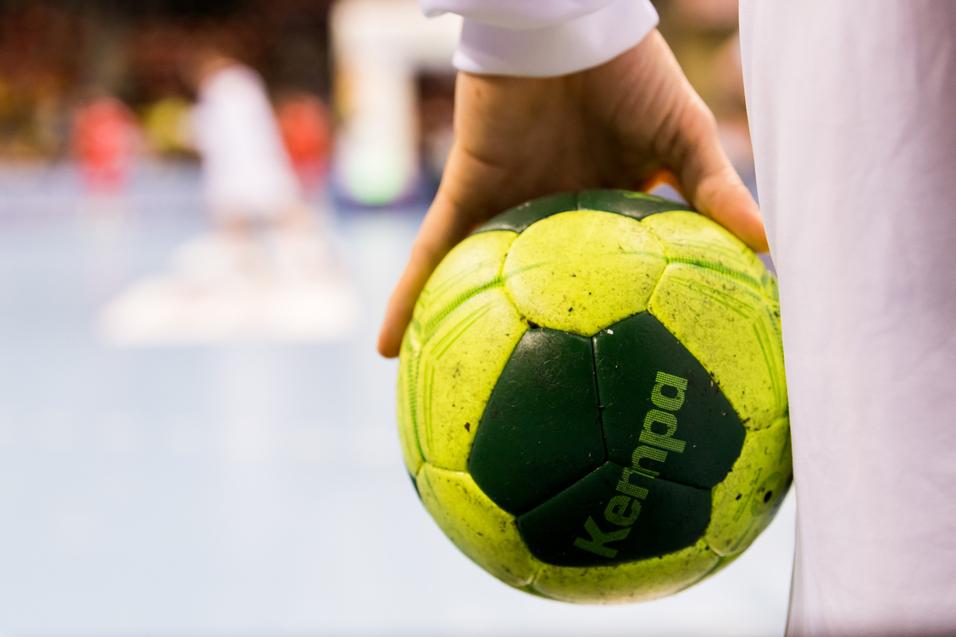Ein Spieler hält einen Handball in der Hand Ein Spieler hält einen Handball in der Hand