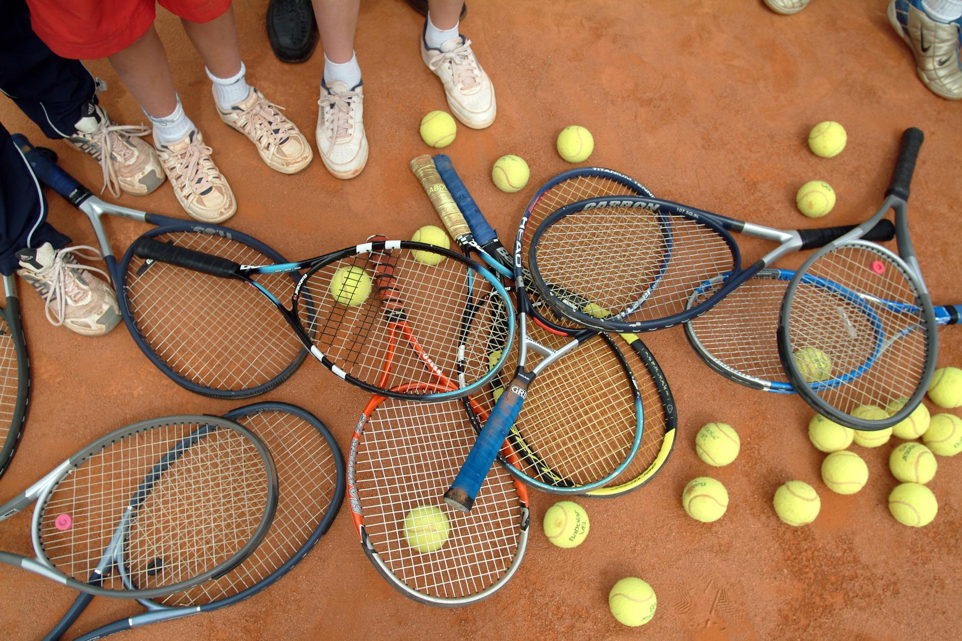 Tennisschläger und -bälle auf einem Tennisfeld Tennisschläger und -bälle auf einem Tennisfeld