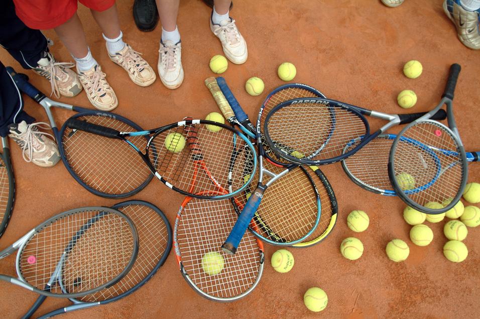 Tennisschläger und -bälle auf einem Tennisfeld Tennisschläger und -bälle auf einem Tennisfeld